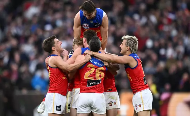 Brisbane Lions Eric Hipwood, top, celebrates with teammates after their win over the Fremantle Dockers in the Australian Football League grand final in Melbourne, Australia Saturday, Sept. 26, 2026. (Joel Carrett/AAP Image via AP)