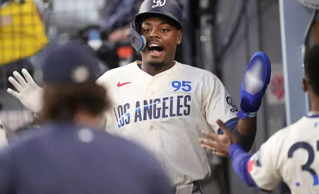 Los Angeles Dodgers' Josue De Paula is congratulated by teammates in the dugout after scoring on a single by Mookie Betts during the second inning of a baseball game against the San Francisco Giants, Saturday, Sept. 19, 2026, in Los Angeles. (AP Photo/Mark J. Terrill)