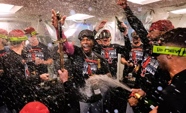 Cleveland Guardians' Angel Martínez, center, celebrates with teammates after clinching a postseason playoff spot following a baseball game against the Boston Red Sox, Thursday, Sept. 24, 2026, in Boston. (AP Photo/Charles Krupa)