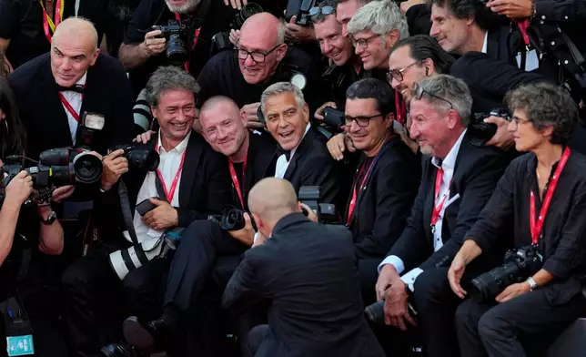 George Clooney, centre, poses with photographers at the opening ceremony and the red carpet for the film 'Ink' during the 83rd edition of the Venice Film Festival in Venice, Italy, on Wednesday, Sept. 2, 2026. (Photo by Alessandra Tarantino/Invision/AP)