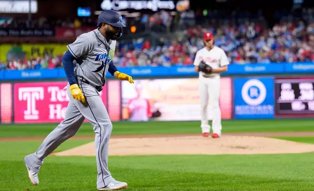 Tampa Bay Rays' Junior Caminero, left, runs after his two-run home run against Philadelphia Phillies starting pitcher Aaron Nola, back right, during the first inning of a baseball game, Saturday, Sept. 26, 2026, in Philadelphia. (AP Photo/Chris Szagola)
