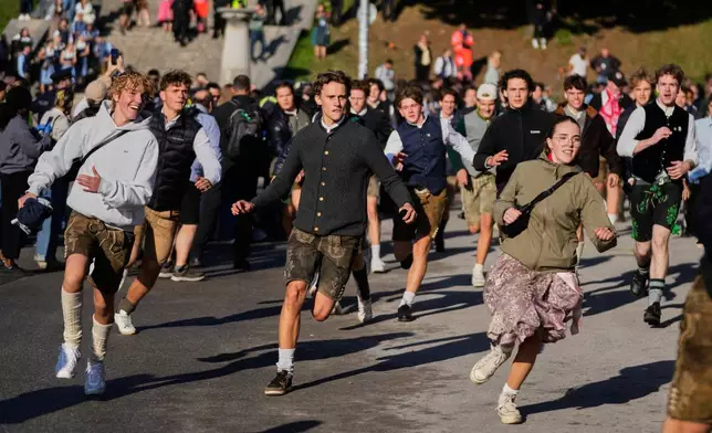 People run to enter the 191st Oktoberfest beer festival in Munich, Germany, Saturday, Sept.19, 2026. (AP Photo/Matthias Schrader)