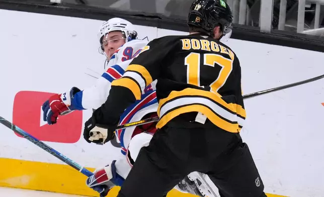 New York Rangers' Gabe Perreault, left, is checked to the ice by Boston Bruins' Will Borgen during the second period of an NHL hockey game, Tuesday, Sept. 29, 2026, in Boston. (AP Photo/Charles Krupa)