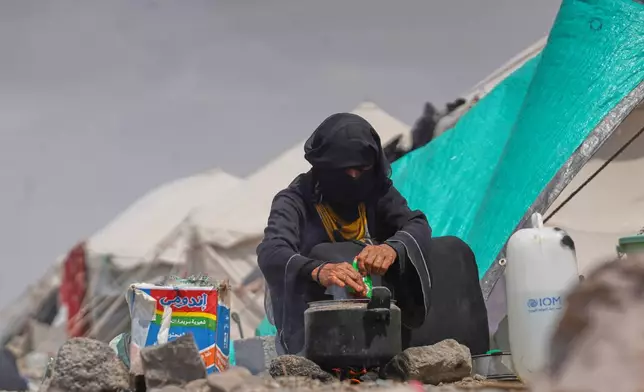A displaced Yemeni cooks at Al-Firdaws camp in Ras Imran, on the western outskirts of Aden, Yemen, Monday, Sept. 21, 2026. (AP Photo/Abdulnasser Alseddik)
