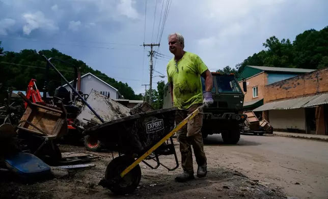 FILE - Jeff Hawkins helps clean his father's antique shop, called Curiosity Shop, Aug. 5, 2022, in Fleming-Neon, Ky., after massive flooding. (AP Photo/Brynn Anderson, File)