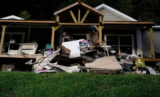 FILE- Kathy Hall throws out damaged belongings Aug. 2, 2022, in Hindman, Ky., in the aftermath of massive flooding. (AP Photo/Brynn Anderson, File)