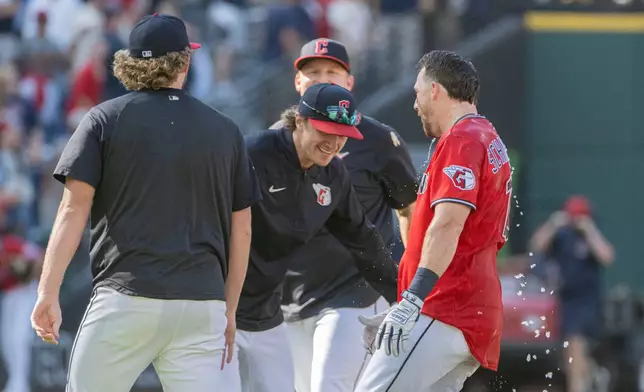 Cleveland Guardians' Daniel Schneemann, right, is greeted by Petey Halpin, center, and other teammates after hitting the winning single in the 10th inning of a baseball game against the Detroit Tigers, Sunday, Sept. 6, 2026, in Cleveland. (AP Photo/Phil Long)