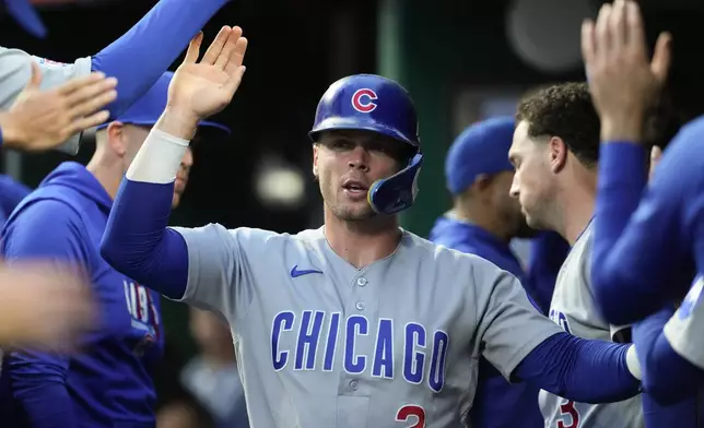 Chicago Cubs' Nico Hoerner is congratulated in the dugout after scoring during the second inning a baseball game against the Cincinnati Reds', Friday, Sept. 18, 2026, in Cincinnati. (AP Photo/Kareem Elgazzar)