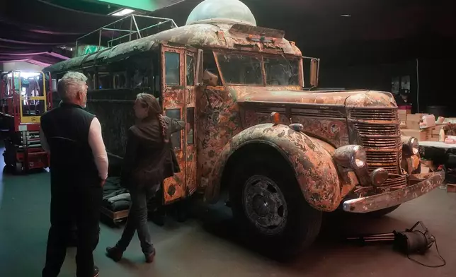 Eric Pirone, left, looks toward Ken Kesey's psychedelic bus "Furthur" where it will be displayed at the Forever Grateful exhibit presented by the Haight Street Art Center at the County Fair Building in Golden Gate Park, Tuesday, Sept. 1, 2026, in San Francisco. (AP Photo/Jeff Chiu)
