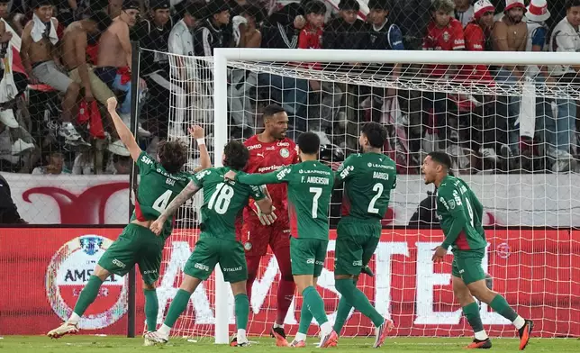 Goalkeeper Carlos Miguel of Brazil's Palmeiras, center, celebrates with teammates at the end of the Copa Libertadores quarterfinal second leg soccer match against Ecuador's Liga Deportiva Universitaria in Quito, Ecuador, Wednesday, Sept. 16, 2026. (AP Photo/Dolores Ochoa)