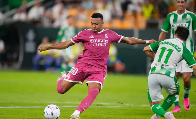 Real Madrid's Kylian Mbappe, left, attempts a shot on goal during the Spanish La Liga soccer match between Real Betis and Real Madrid in Seville, Spain, Friday, Sept. 4, 2026. (AP Photo/Jose Breton)