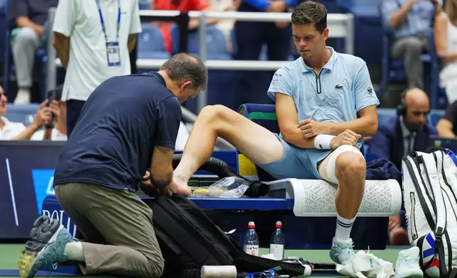Alexander Blockx, of Belgium, has his foot checked during a medical timeout during a match against Karen Khachanov, of Russia, during the quarterfinal round of the U.S. Open tennis championships, Wednesday, Sept. 9, 2026, in New York. (AP Photo/Kirsty Wigglesworth)