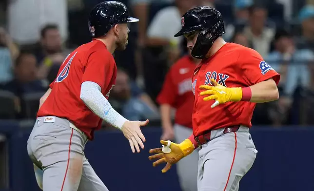 Boston Red Sox's Trevor Story, left, and Caleb Durbin celebrate after scoring on a two-run single by Roman Anthony off Tampa Bay Rays pitcher Ian Seymour during the second inning of a baseball game Friday, Sept. 18, 2026, in St. Petersburg, Fla. (AP Photo/Chris O'Meara)
