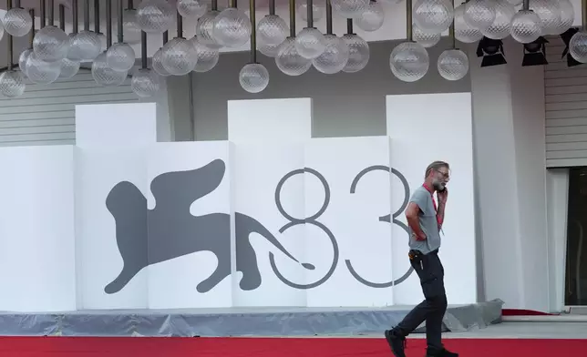 A worker makes a telephone call on the red carpet prior to the 83rd edition of the Venice Film Festival in Venice, Italy, on Monday, Aug. 31, 2026. (Photo by Alessandra Tarantino/Invision/AP)