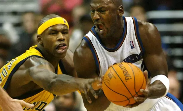 FILE - Washington Wizards' Michael Jordan gets control of the ball with pressure from Indiana Pacers' Al Harrington in the fourth quarter of play, Jan. 4, 2003, in Washington. (AP PHoto/Lawrence Jackson, File)