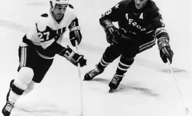 FILE - Gordie Howe, right, of the Houston Aeros, comes in to head Tom Earl of the New England Whalers off rom the puck during the first period of the World Hockey Association playoff game in Hartford, Conn., May 11, 1976. (AP Photo/Bob Child, File)