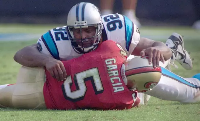 FILE - Carolina Panthers' Reggie White (92) sacks San Francisco 49ers quarterback Jeff Garcia (5) in the fourth quarter of the Panthers' win in Charlotte, N.C., Oct. 22, 2000. (AP Photo/Chuck Burton, File)