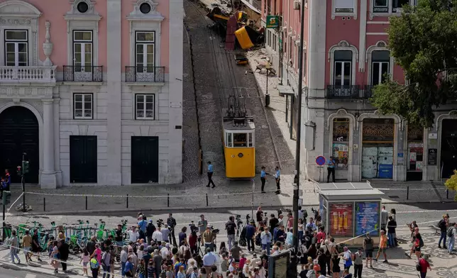 FILE - People look at a streetcar that derailed and crashed in Lisbon, Portugal, Sept. 4, 2025. (AP Photo/Armando Franca, File)