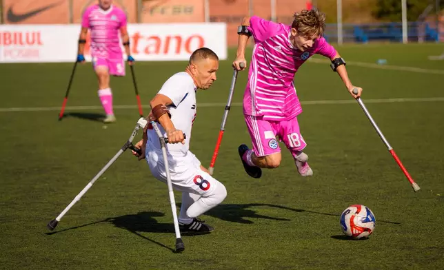 FCSB's Marian Sacacol, left, challenges for the ball with Ayr United's Charlie Hewson during an amputee soccer match between FCSB and Ayr United in the inaugural EAFF Conference League in Bucharest, Romania, Thursday, Sept. 24, 2026. (AP Photo/Andreea Alexandru)
