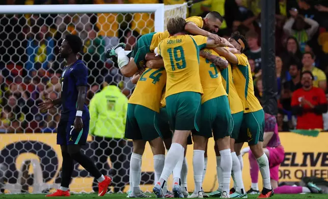 Australian players celebrate a goal by Connor Metcalfe during their international friendly soccer match against Brazil in Brisbane, Australia, on Tuesday, Sept. 29, 2026. (AP Photo/Tertius Pickard)