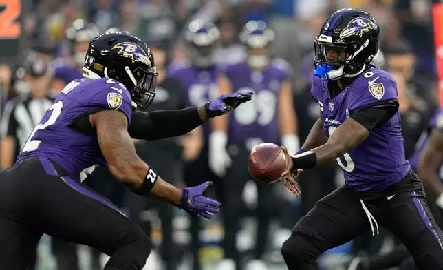 Baltimore Ravens quarterback Lamar Jackson (8) hands off to running back Derrick Henry (22) during the first half of an NFL football game in Rio de Janeiro, Sunday, Sept. 27, 2026. (AP Photo/Fernando Llano)