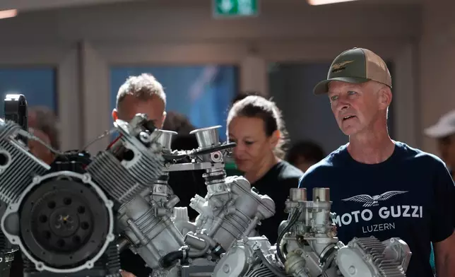 Visitors look at the Moto Guzzi motorcycle engines on display at the museum during the Moto Guzzio pening inaugurating its completely redeveloped historic factory and new museum as the motorcycle maker celebrates its 105th anniversary, in Mandello del Lario, Thursday, Sept. 3, 2026. (AP Photo/Luca Bruno)