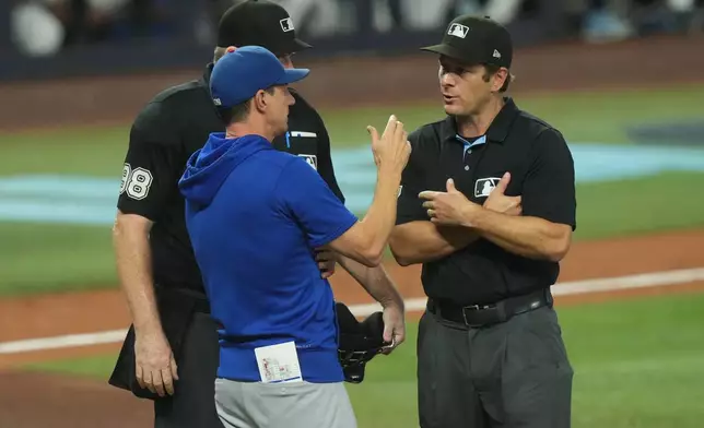 Chicago Cubs manager Craig Counsell talks to referees Ben May and Chris Conroy (98) about a call during the fourth inning of a baseball game against the Miami Marlins Saturday, Sept. 5, 2026, in Miami. (AP Photo/Marta Lavandier)
