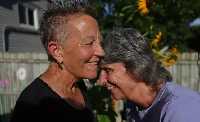 Deb Robertson, left, and her wife, Kate Koubek, laugh in the backyard of their home in Lombard, Ill., on Tuesday, Sept. 8, 2026. (AP Photo/Luis Andres Henao)