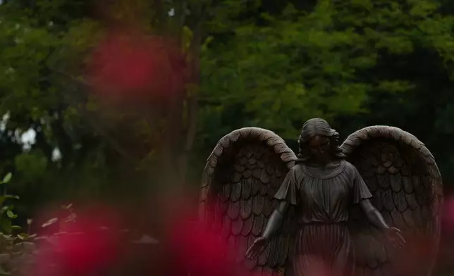 A sculpture of an angel stands the gardens at a memorial for survivors and lives lost to suicide dedicated by the Archdiocese of Chicago at Queen of Heaven Catholic Cemetery in Hillside, Ill., on Wednesday, Sept. 9, 2026. (AP Photo/Luis Andres Henao)