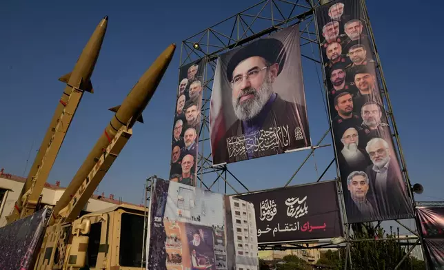 Iranian missiles and banners showing portraits of the Iranian Supreme Leader Ayatollah Mojtaba Khamenei, center, and the late armed forces commanders and nuclear scientists, who were killed in Israel and U.S. strikes, are displayed in a military exhibition commemorating the anniversary of the start of the 1980-88 Iraq-Iran war at Baharestan Square, in Tehran, Monday, Sept. 28, 2026. (AP Photo/Vahid Salemi)