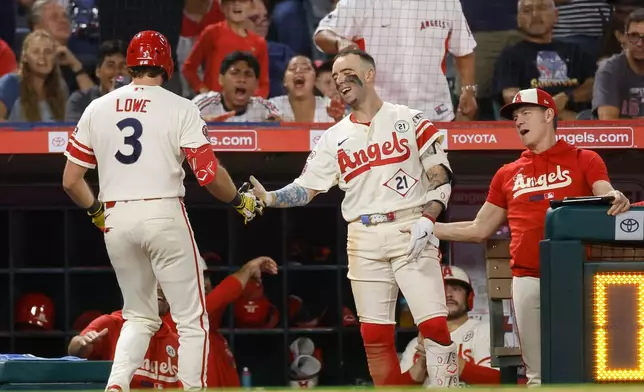 Los Angeles Angels' Josh Lowe (3), left, is greeted by teammates after hitting a solo home run during the sixth inning of a baseball game against the Seattle Mariners, Tuesday, Sept. 15, 2026, in Anaheim, Calif. (AP Photo/Caroline Brehman)