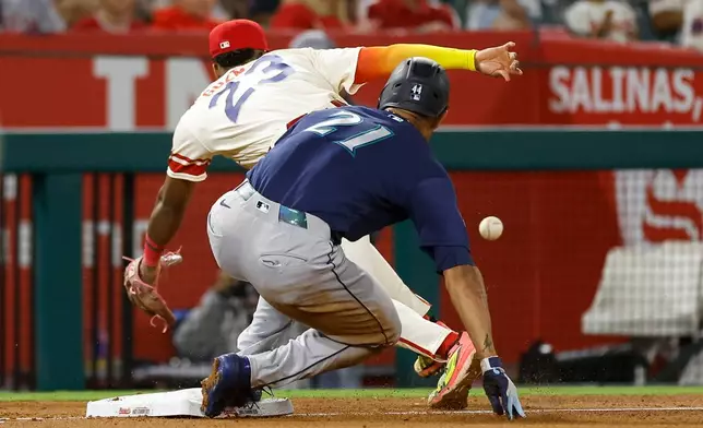 Seattle Mariners' Julio Rodriguez, front, runs to third base as Los Angeles Angels third baseman Denzer Guzman, back, reaches for the ball during the sixth inning of a baseball game Tuesday, Sept. 15, 2026, in Anaheim, Calif. (AP Photo/Caroline Brehman)