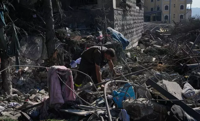 A rescue worker searches for victims under the rubble of a building destroyed in an Israeli airstrike in the southern village of Kfar Rumman, Lebanon, Monday, Sept. 7, 2026. (AP Photo/Mohammed Zaatari)