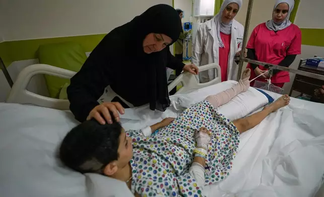 Mustafa Farhat, 8, who was injured in an Israeli airstrike that hit his home and killed his parents, is comforted by his grandmother at a hospital in the town of Nabatiyeh, southern Lebanon, Monday, Sept. 7, 2026. (AP Photo/Mohammed Zaatari)