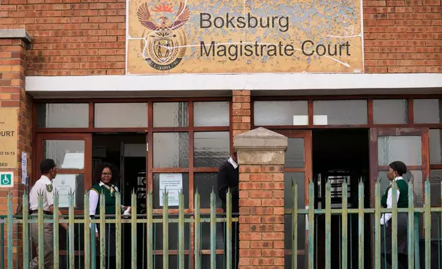 Court workers are seen at the entrance of the Boksburg Magistrate Court, east of Johannesburg, South Africa, Monday, Sept. 21, 2026, where suspects appeared in connection with one of a series of killings of women near Johannesburg. (AP Photo/Themba Hadebe)
