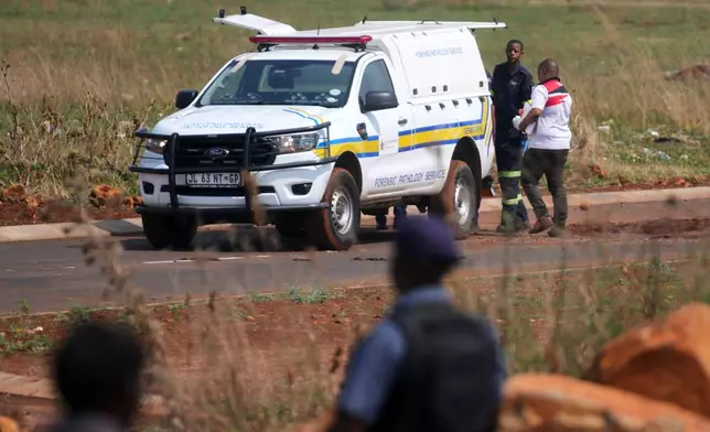 Forensic investigators work at the site where the body of a woman was discovered on the outskirts of Johannesburg, South Africa, Thursday, Sept. 17, 2026. (AP Photo/Themba Hadebe)