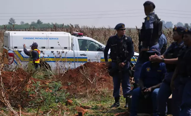 Forensic investigators work at the site where the body of a woman was discovered on the outskirts of Johannesburg, South Africa, Thursday, Sept. 17, 2026. (AP Photo/Themba Hadebe)