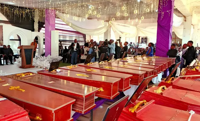 People attend a funeral ceremony for school children who died in a fire that swept through two schools in the city of Bukavu, eastern Congo, Monday, Sept. 14, 2026. (AP Photo/Janvier Barhahiga)