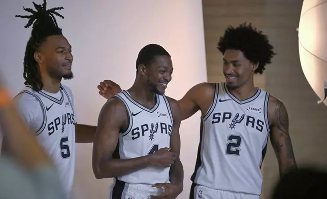 San Antonio Spurs players Dylan Harper (2), De'Aaron Fox, and Stephon Castle (5) pose for photos during the team's NBA basketball media day event, Monday, Sept. 28, 2026, in San Antonio. (AP Photo/Darren Abate)