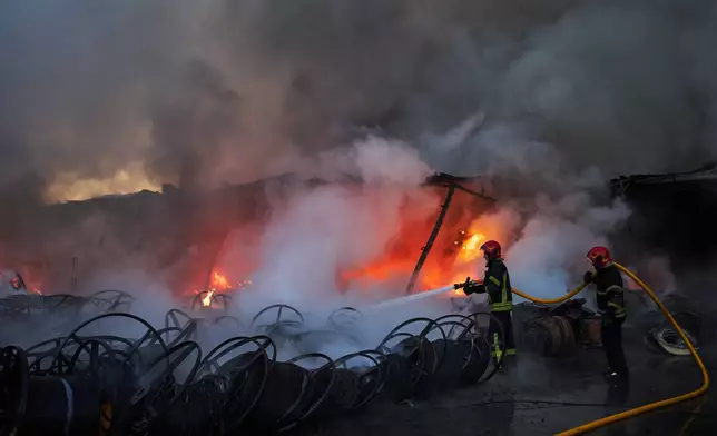 Firefighters try to extinguish a fire following a Russian missile attack in Kyiv, Ukraine, early Tuesday, Sept. 8, 2026. (AP Photo/Francisco Seco)