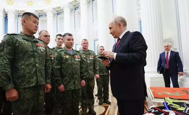 FILE - Russian President Vladimir Putin, foreground right, speaks with members of the military in the Kremlin in Moscow on Friday, June 12, 2026, as Defense Minister Andrei Belousov, right, stands nearby. (Vyacheslav Prokofyev, Sputnik, Kremlin Pool Photo via AP, File)
