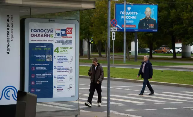 FILE - A sign reading "Vote online, reliable, affordable, simple" for Russia's parliamentary election is displayed at a bus stop in Moscow, Russia, Monday, Sept. 14, 2026, with a billboard in the background showing a soldier with the words "Russia's Pride." (AP Photo/Alexander Zemlianichenko, File)