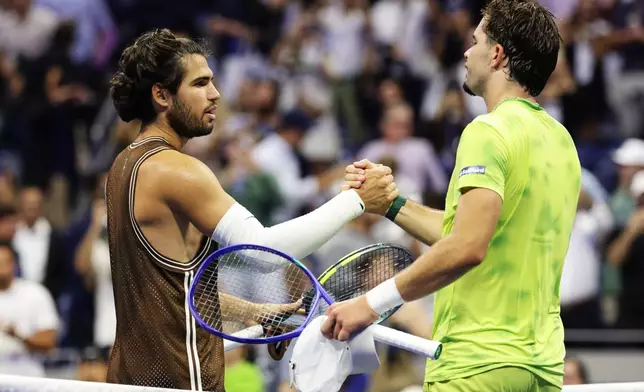 Carlos Alcaraz, of Spain, left, meets Jaime Faria, of Portugal, at the net after winning a match during the second round of the U.S. Open tennis championships, Wednesday, Sept. 2, 2026, in New York. (AP Photo/Adam Hunger)