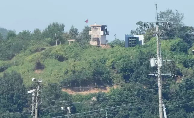 North Korean soldiers stand at a North Korean military guard post near a flying national flag, seen from Paju, South Korea, near the border with North Korea, Wednesday, Sept. 16, 2026. (AP Photo/Ahn Young-joon)