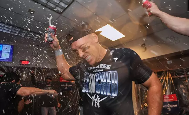 New York Yankees' Aaron Judge, center, celebrates with teammates after they clinched the playoffs in a baseball game against the Minnesota Twins, Monday, Sept. 14, 2026, in Minneapolis. (AP Photo/Abbie Parr)
