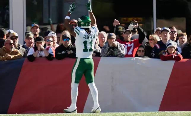 New York Jets wide receiver Omar Cooper Jr. (11) celebrates and taunts New England Patriots fans after scoring a touchdown during the second half of an NFL football game in Foxborough, Mass., Sunday, Oct. 18, 2026. (AP Photo/Charles Krupa)