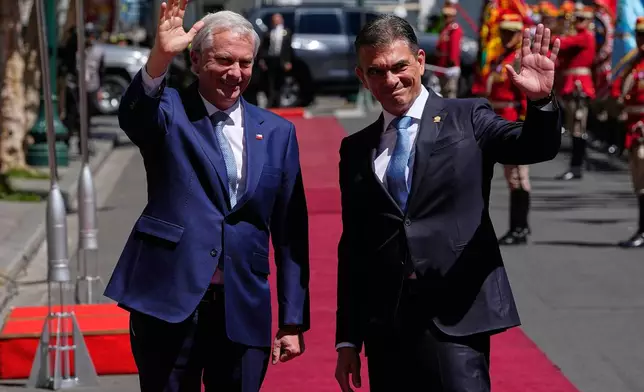 Bolivian President Rodrigo Paz, right, and Chile's President Jose Antonio Kast wave outside at the government palace in La Paz, Bolivia, Friday, Oct. 16, 2026. (AP Photo/Juan Karita)