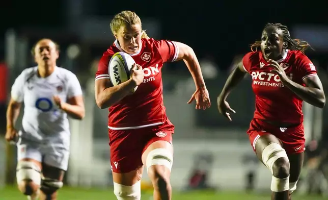 Canada's Sophie de Goede, center, scores a try against England as teammate Julia Omokhuale follows in the first half of a rugby match in Ottawa, Ontario, Friday, Oct. 23, 2026. (Justin Tang/The Canadian Press via AP)