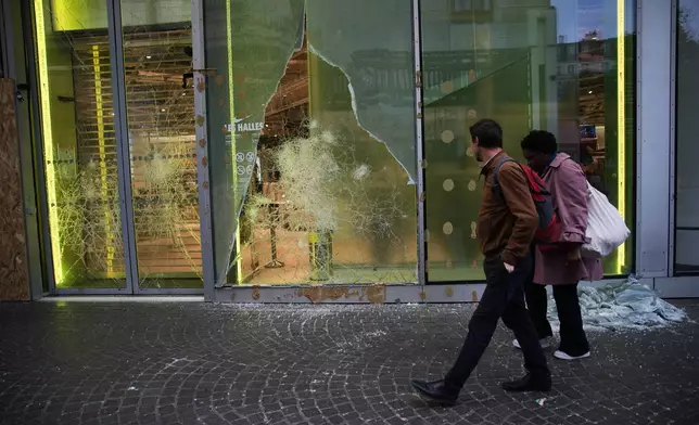People walk past a looted store, after violence erupted during nationwide protests against rising living costs and poor conditions in schools, in Paris, Monday, Oct. 19, 2026. (AP Photo/Christophe Ena)