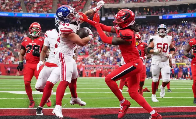 New York Giants running back Cam Skattebo (44) scores with Houston Texans safety Calen Bullock, front right, defending during the second half of an NFL football game in Houston, Sunday, Oct. 25, 2026. (AP Photo/Eric Smith)
